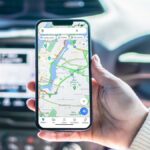 Girl,Inside,Car,Holding,Smartphone,With,Google,Maps,App,On