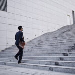 Business executive with briefcase going up the stairs